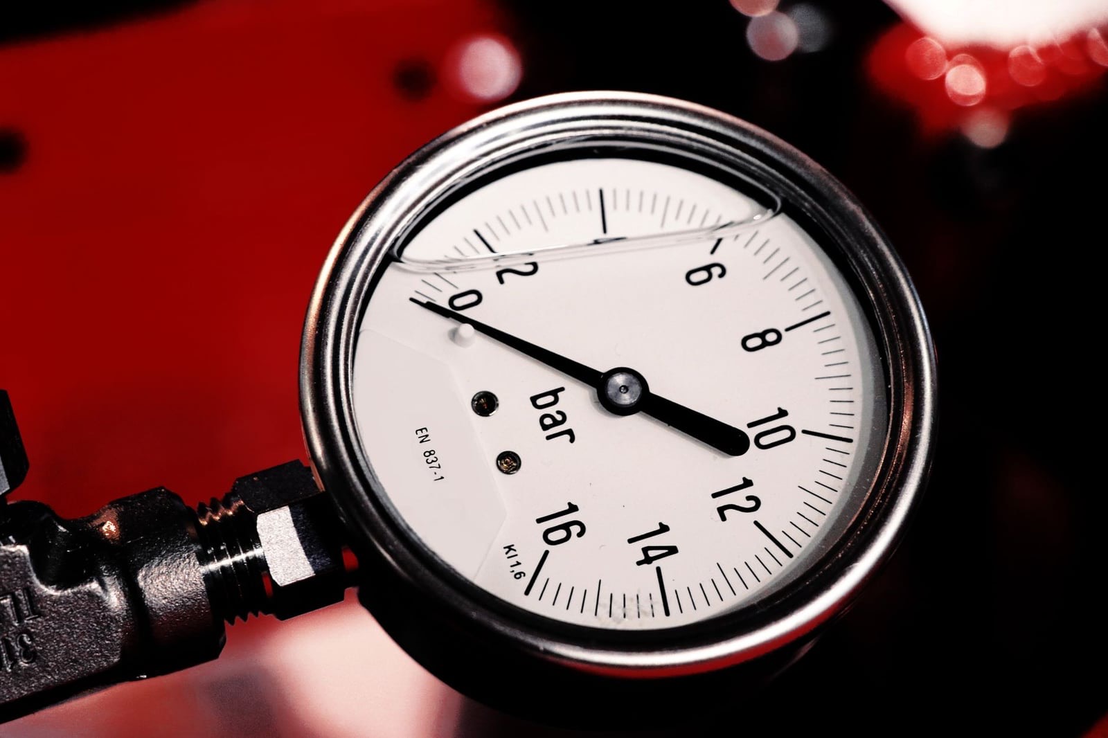 A pressure gauge with a dial marked in bar