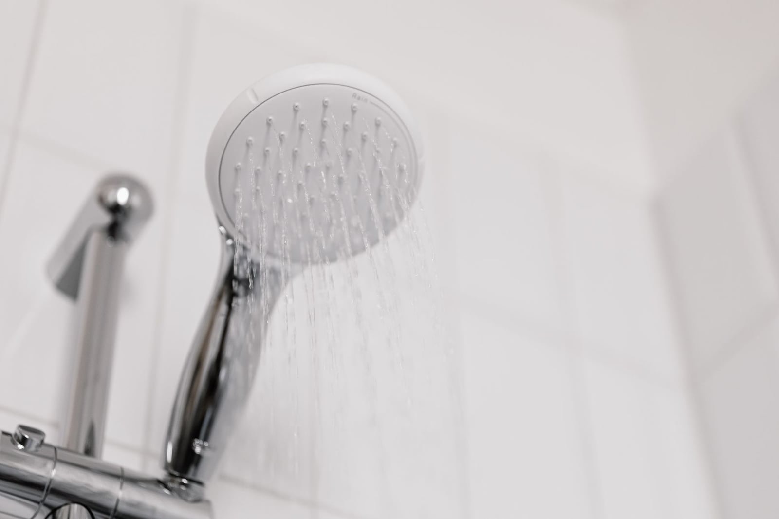 A shower running in a tiled bathroom